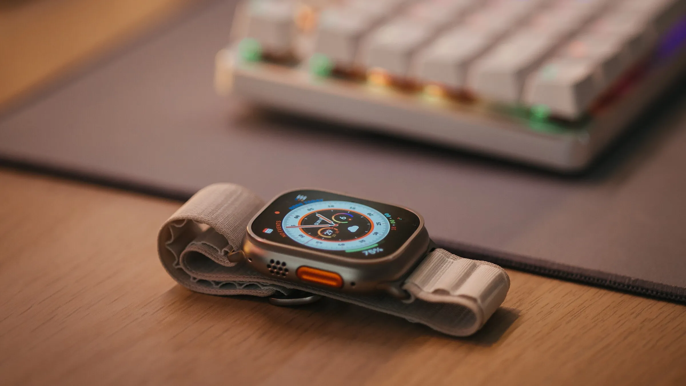 A sleek smart watch rests on a desk beside a keyboard, ready to assist with daily tasks and track fitness goals.