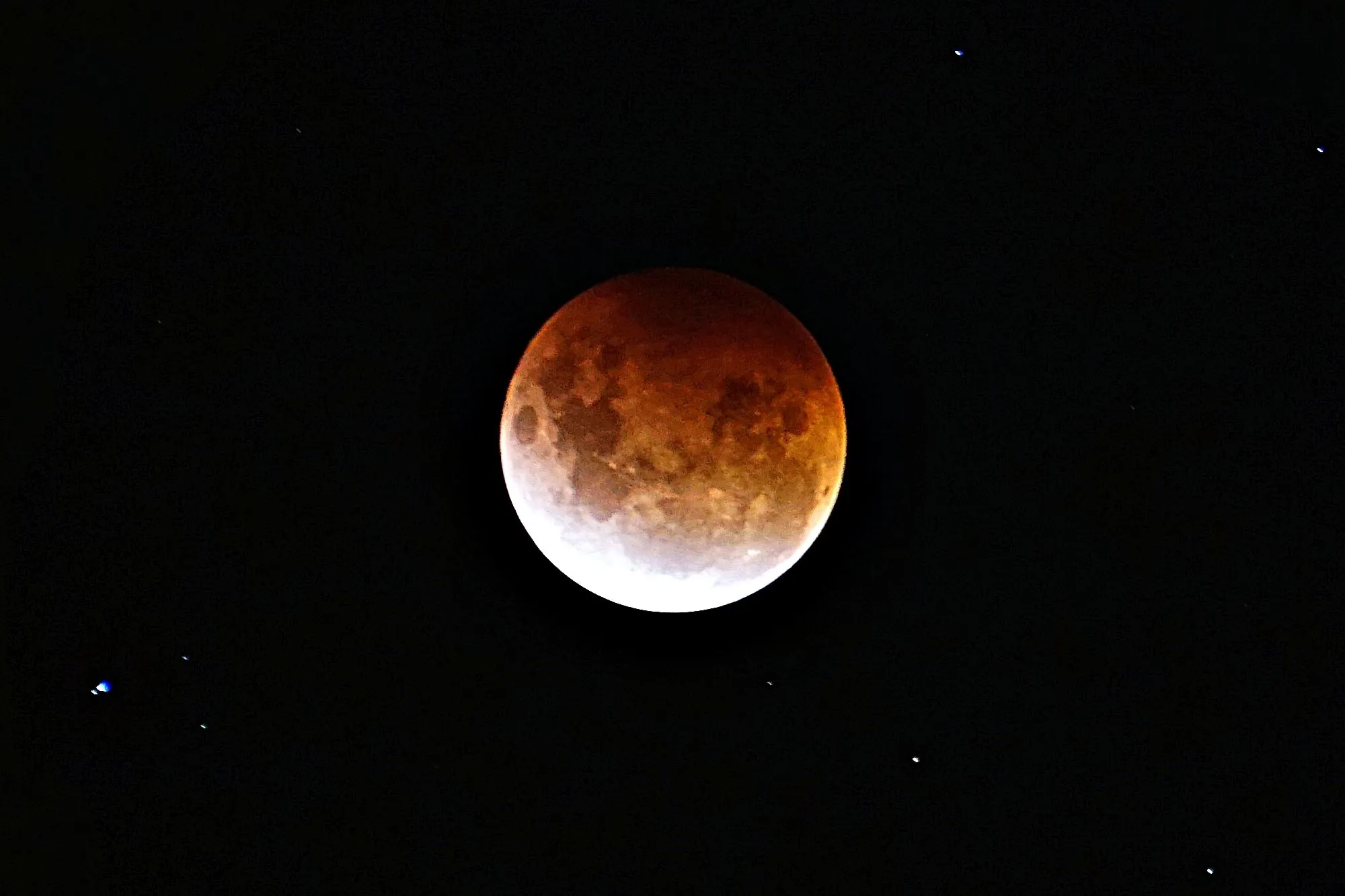 A red blood moon during a total lunar eclipse, with the text "Witness the Beauty of a Lunar Eclipse Safely."