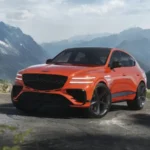 Luxury orange SUV parked on a scenic mountain road.